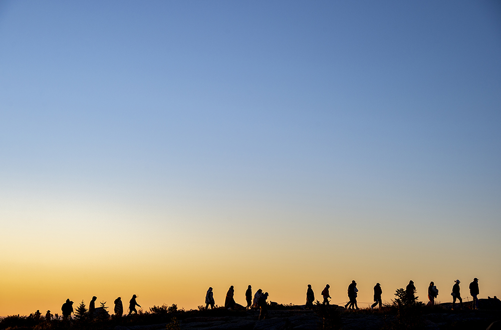 Park visitors walk from the summit of Cadillac mountain after watching the sun rise in Acadia National Park.